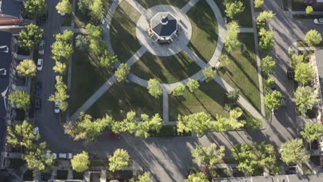 Vista-De-Pájaro-Volar-Sobre-La-Réplica-Del-Suburbio-De-Inverness-Hay-Una-Isla-En-El-Centro-De-La-Calle-Residencial-Que-Conduce-A-La-Plaza-Comunitaria-Exuberante-Parque-Con-Mirador-En-El-Centro-Durante-El-Amanecer-De-Verano-5-5