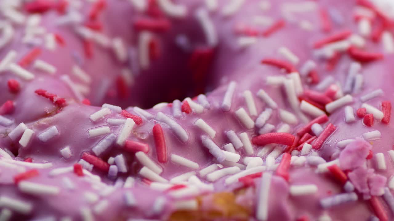 donut rosado esmaltado de primer plano en un plato gira. bocadillos dulces horneado. comida dulce alta en calorías. donuts favoritos para niños. pastel de donut para el desayuno. enfoque selectivo, profundidad de campo poco profunda.