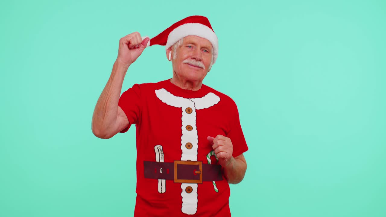 크리스마스 할아버지가 이어폰을 통해 음악을 듣고, 디스코를 춤추고, 재미를 즐기고 있습니다.