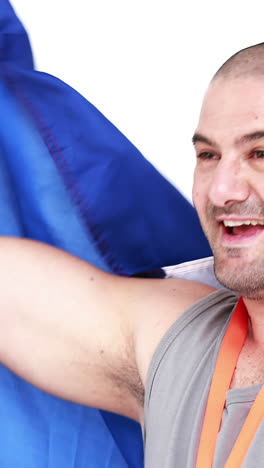 atleta feliz con una medalla sosteniendo una bandera