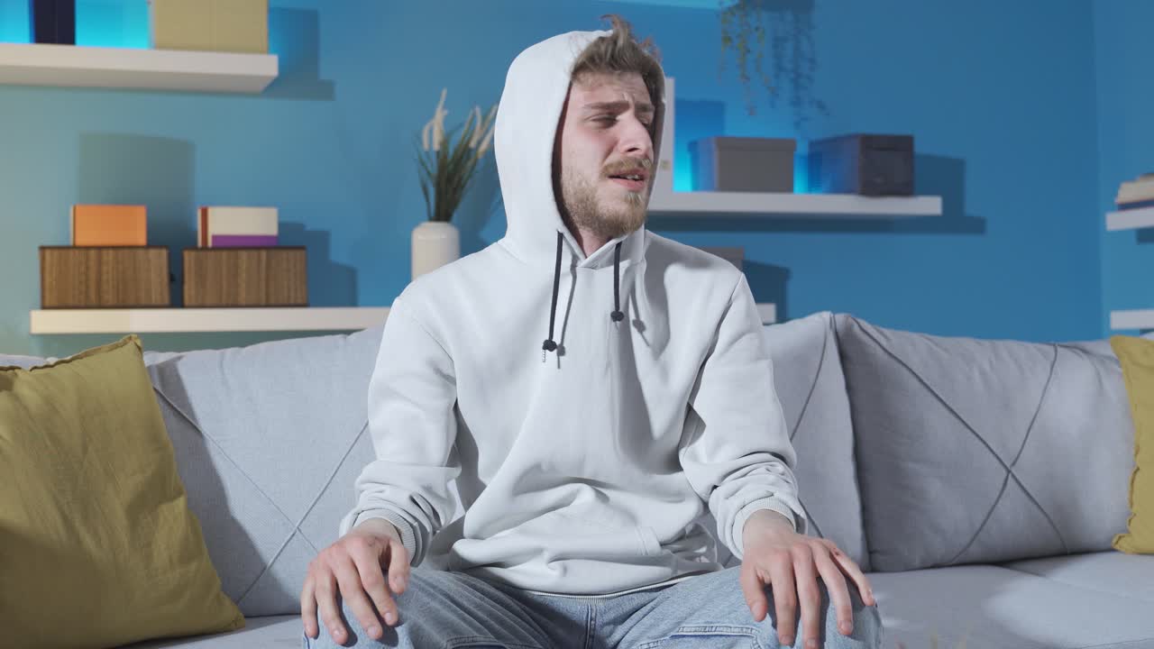 депрессивный и агрессивный молодой человек без мотивации беспомощен дома.