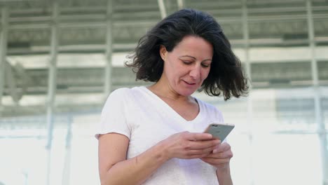 Erfolgreiche-Reife-Frau-Mit-Smartphone-Im-Freien.