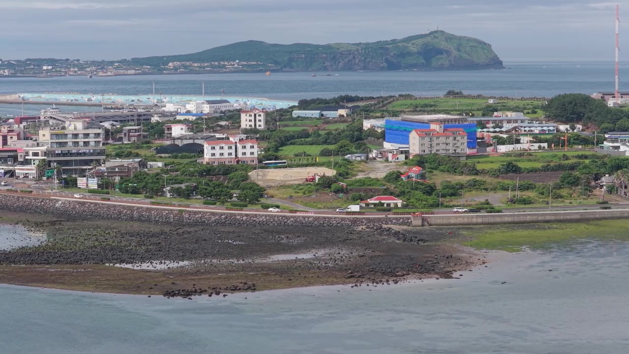 Auto che guidano sulla strada costiera nella città di Seongsan sull'isola di Jeju, Corea del Sud. Ripresa aerea.