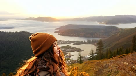 woman enjoying sunset views from a mountain in a forested area
