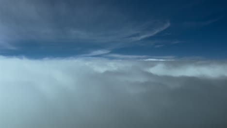 immersive pilot pov flying ove a blanket of fluffy stratus clouds at the eyes of the pilots of a jet from cockpit. 4k 60fps