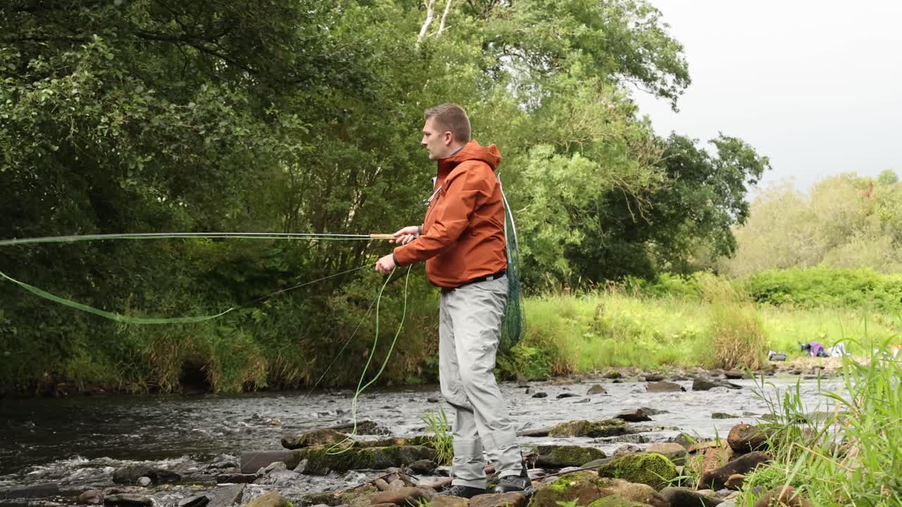 ручной снимок рыбака-мухи, проверяющего свои приманки и линию, чтобы не запутаться