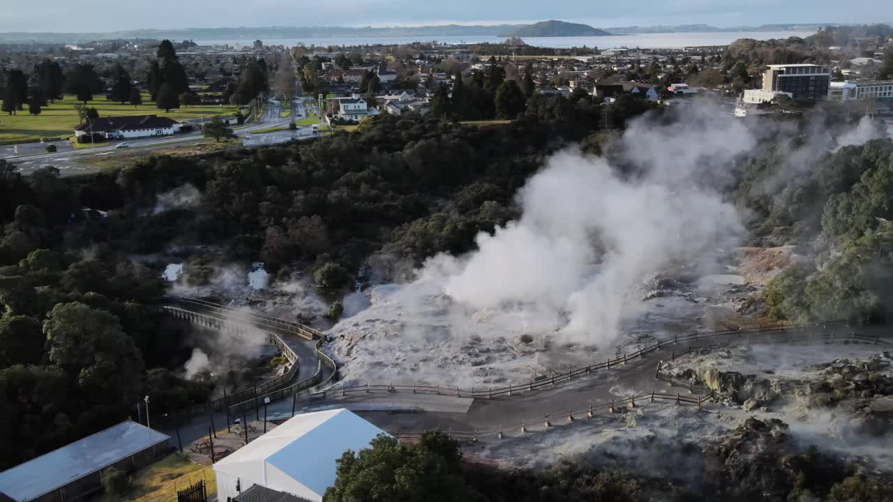 Ångande gejser i en maoriby och drönarlandskap över sjön Rotorua. Resmål Nya Zeeland