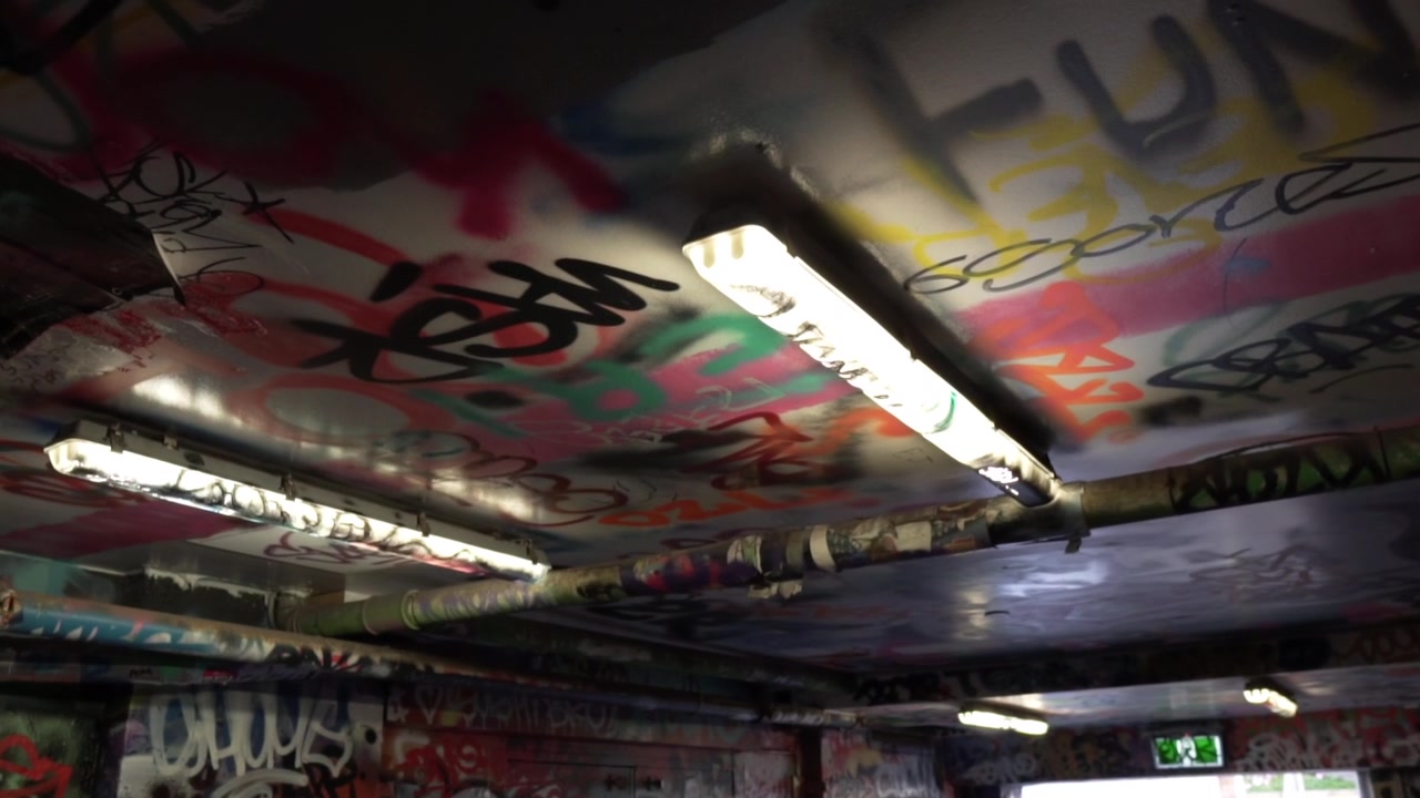 Ceiling covered in graffiti made up of words in an abandoned place, slow motion