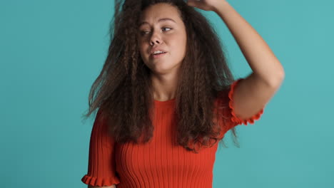 mujer caucásica de cabello rizado frente a la cámara.