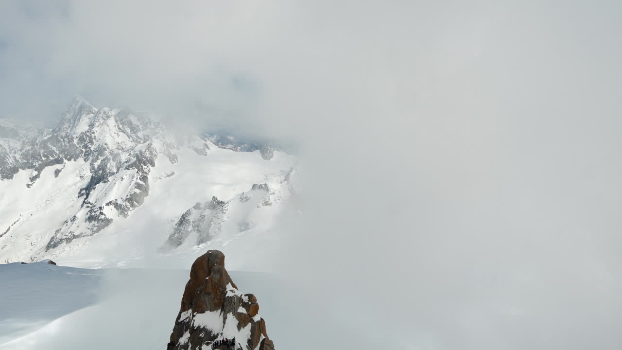 el lapso de tiempo de las nubes que cubren los picos nevados de los alpes franceses en un soleado día de invierno