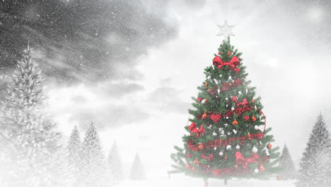 snow falling over christmas tree and multiple snow covered trees on winter landscape