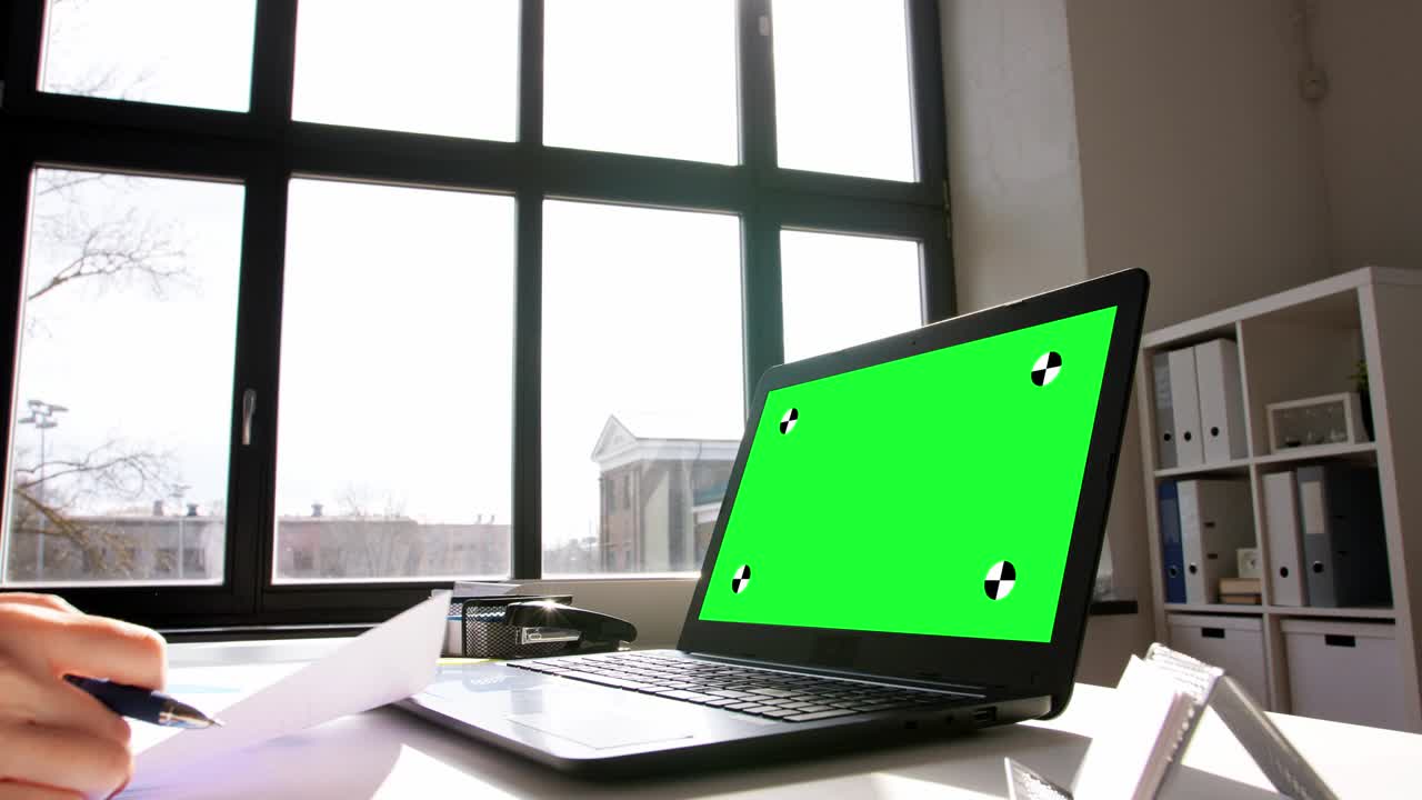 mujer con portátil y gráficos trabaja en la oficina de casa