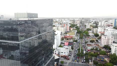 Vista-De-Drone-Ascendiendo-Con-Vista-Del-Tráfico-De-La-Ciudad-Desde-La-Avenida-Principal-Nuñez-De-Caceres-Santo-Domingo