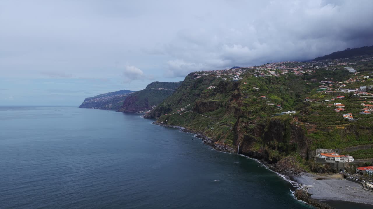 Aerial view of Ponta do Sol village, nestled on the steep cliffs of Madeira Island, overlooking the vast Atlantic Ocean. Push Forward