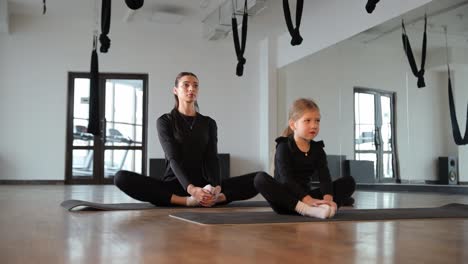 woman and child practicing yoga or stretching exercises