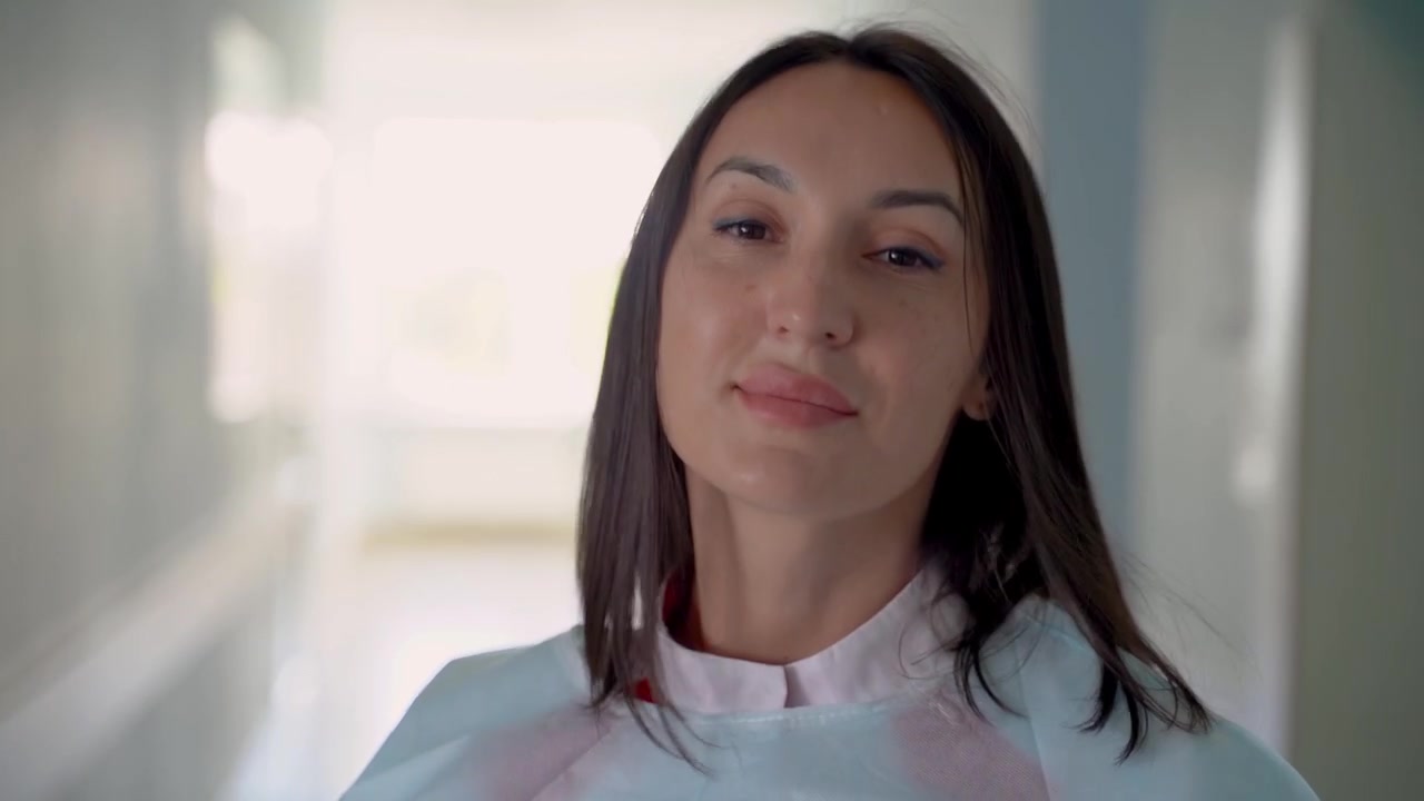 Doctora se quita su mascarilla médica y sonríe