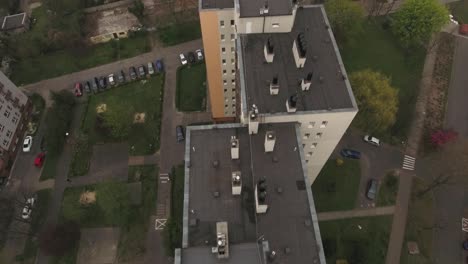 roofs of blocks with chimneys in central europe, surrounded by lawns, cars, and trees during spring