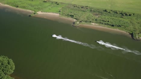 Aerial-drone-view-at-the-Meuse-river-and-some-boats-passing-by-in-the-Netherlands,-Europe