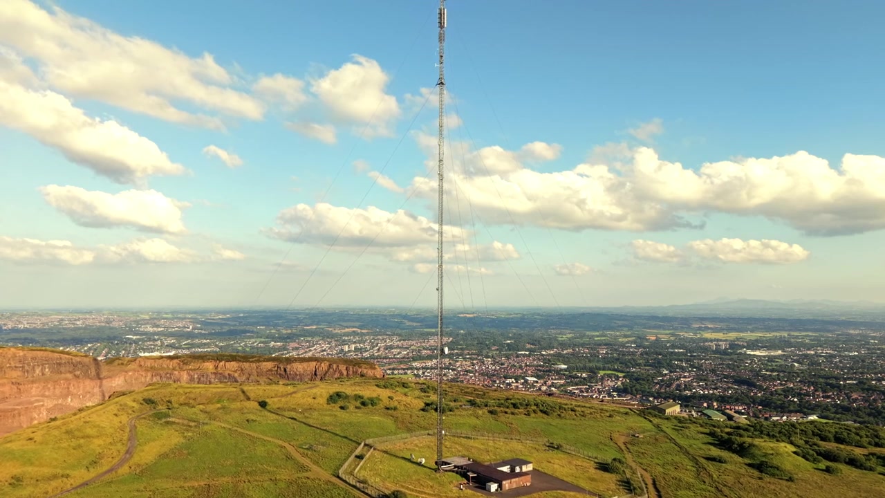 Vídeo aéreo 4K 60FPS em plano médio da Estação Transmissora Black Mountain em West Belfast, Irlanda do Norte, no Reino Unido, em um dia ensolarado e claro. Produzido com cor Rec709