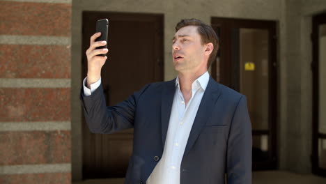 Closeup-businessman-talking-face-time-outdoors.-Man-using-video-call-at-street