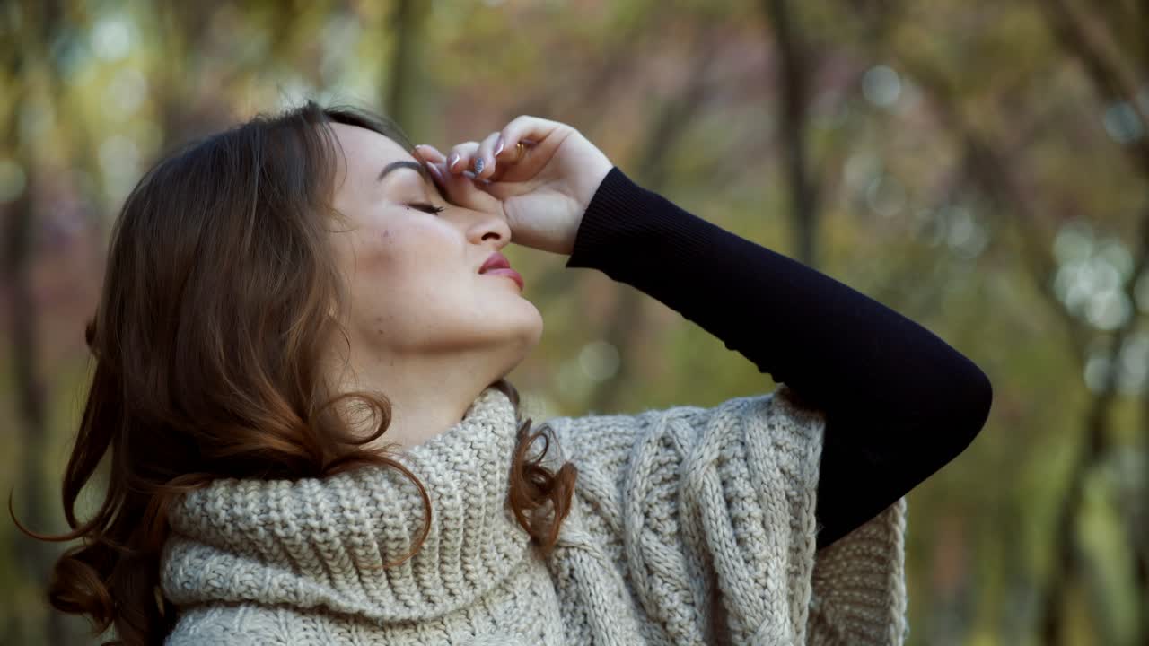 Woman relaxing in park. Happy attractive woman relaxing in sunny autumn park