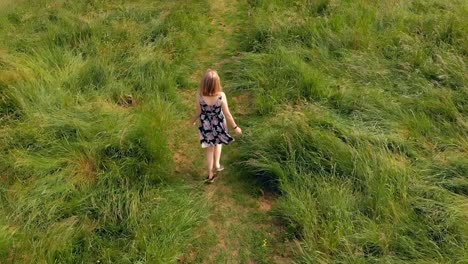 woman walking on green field 4k