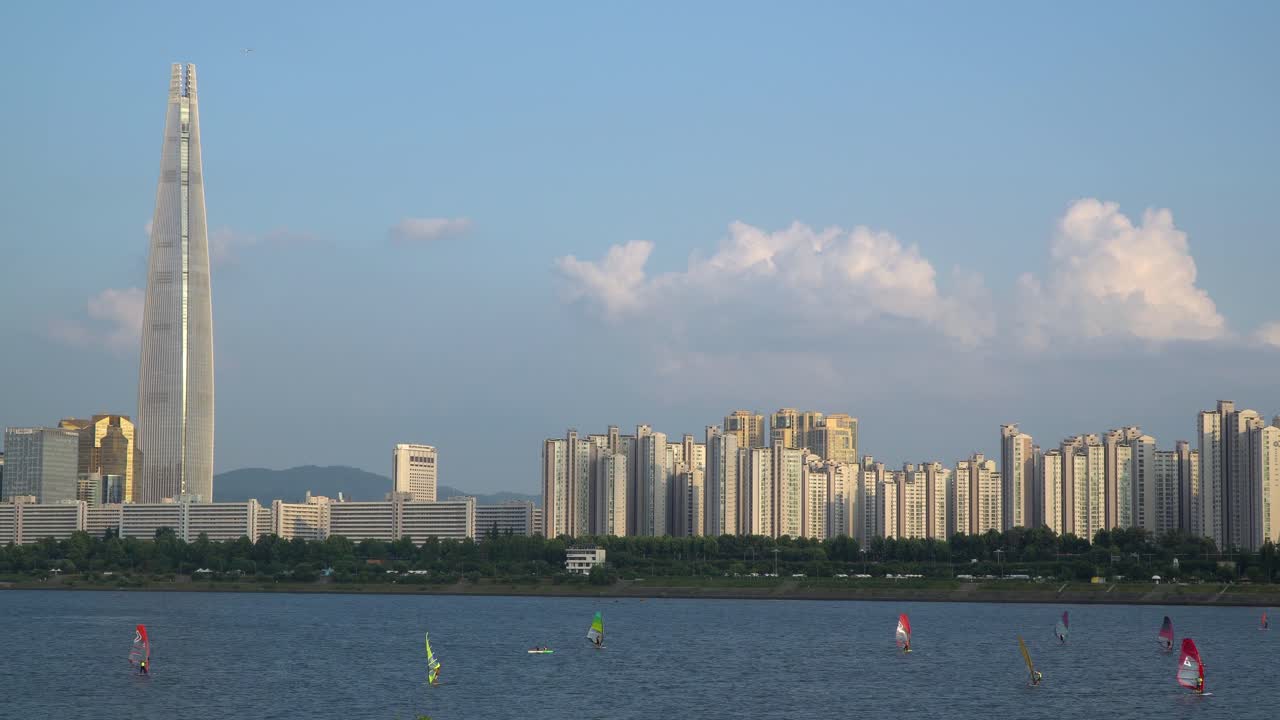한국 서울 잠실구 롯데타워 인근 한강에서 한 무리의 남성들이 윈드서핑을 하고 있다.