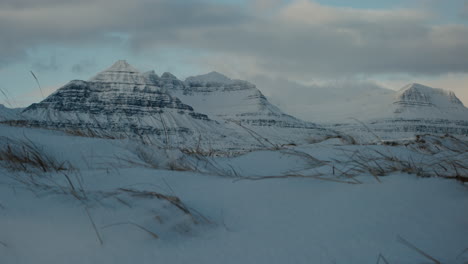 Er-Erhebt-Sich-über-Schneebedeckte-Grasfelder-Und-Bildet-Bei-Sonnenuntergang-Die-Arktischen-Bergrücken