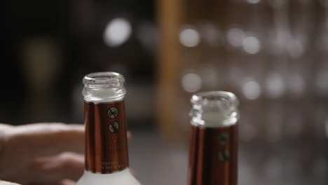 primer plano de las manos de un hombre mientras abre una botella en cámara lenta
