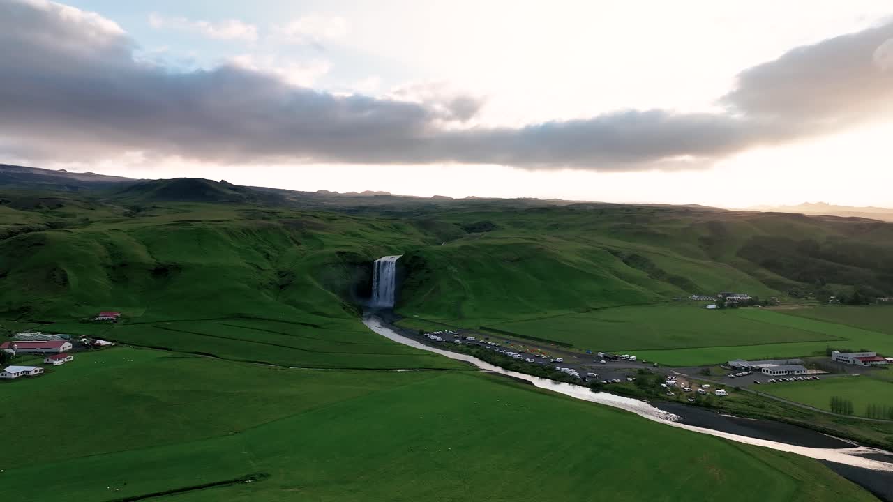 los alrededores verdes que rodean la cascada de skogafoss en el sur de islandia - panorámica aérea a la izquierda