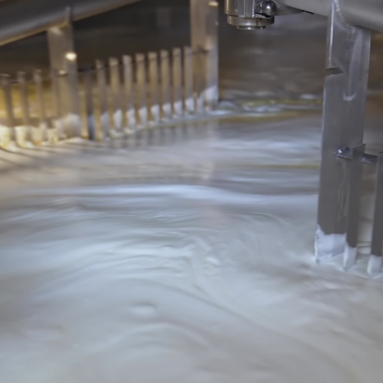 Process of making butter on a milk farm. Industrial equipment mixing dairy liquid for butter production. Close-up