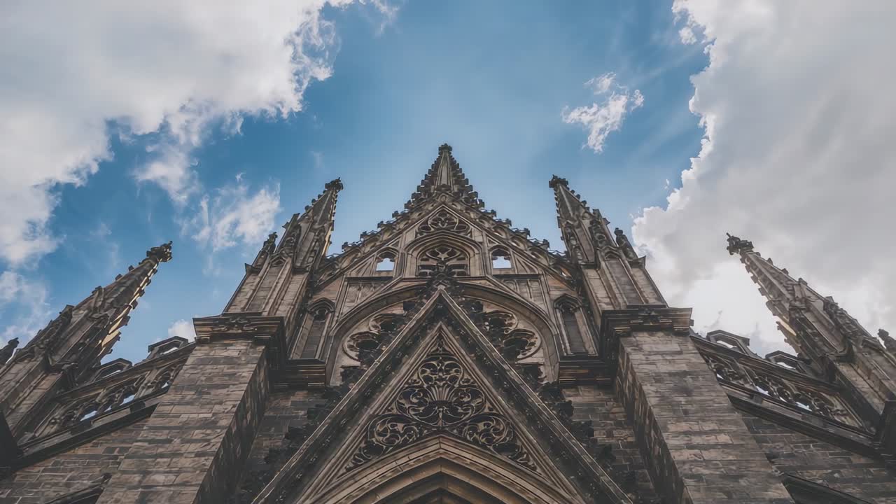 Tilting camera upward from low-angle cathedral facade in plaza, showing twin spires, carved tracery