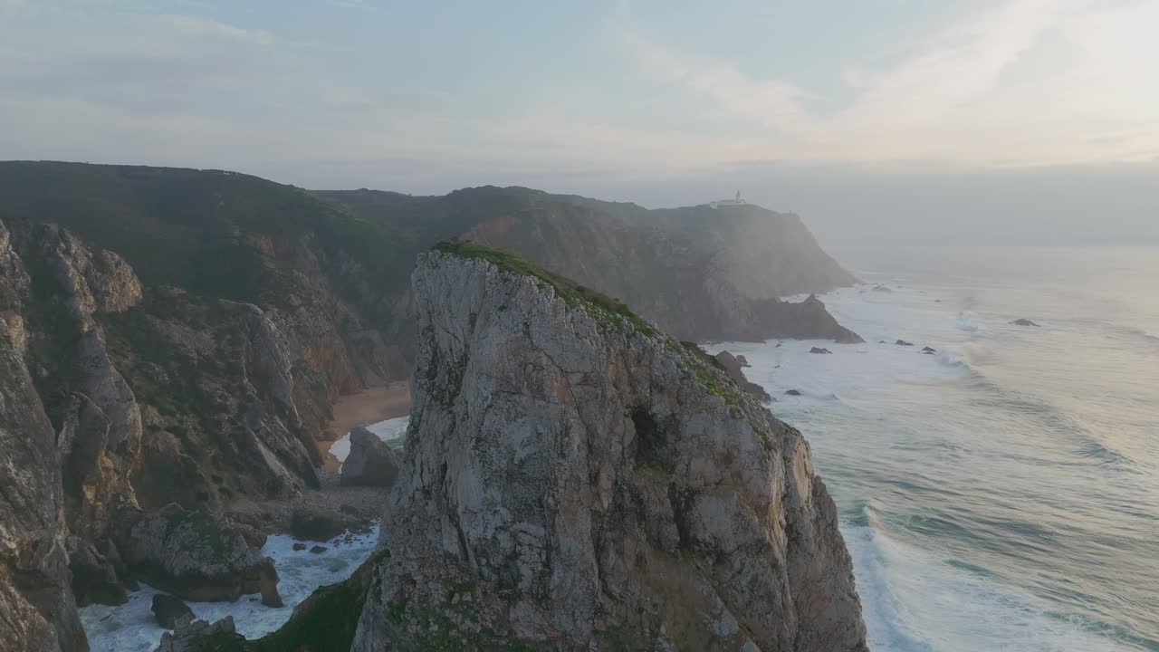 Aerial revealing shot of Ursa Beach in Portugal with reaching waves between rocks and cliffs