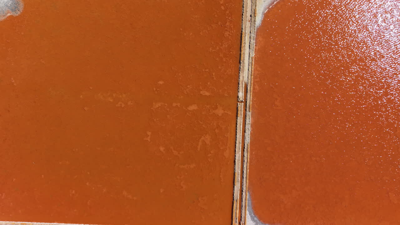 Aerial drone view of colorful salt pans in Sicily with stunning geometric shapes and textures, unique natural patterns from above