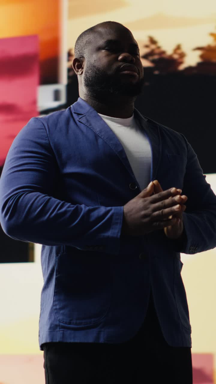 African American Man Praying with Eyes Closed in Front of Religious Imagery