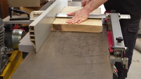 flattening piece of ash wood on jointer machine