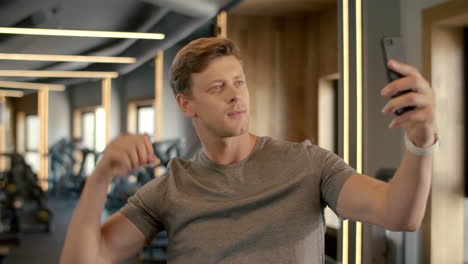 young sportsman making selfie photo at gym. bodybuilder standing in sport club