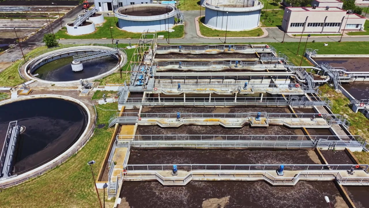 Environmental management at wastewater treatment facility observed from above. Unmanned aerial vehicle captures detailed view of sewage treatment infrastructure and processes