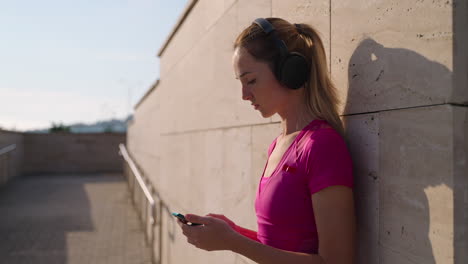 woman using phone while resting outdoors during a workout