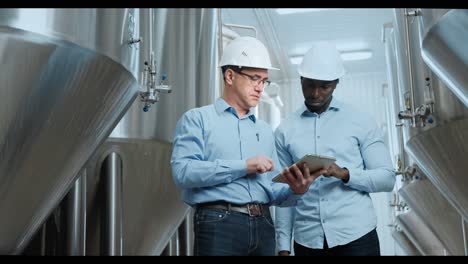 brewery employees inspecting equipment