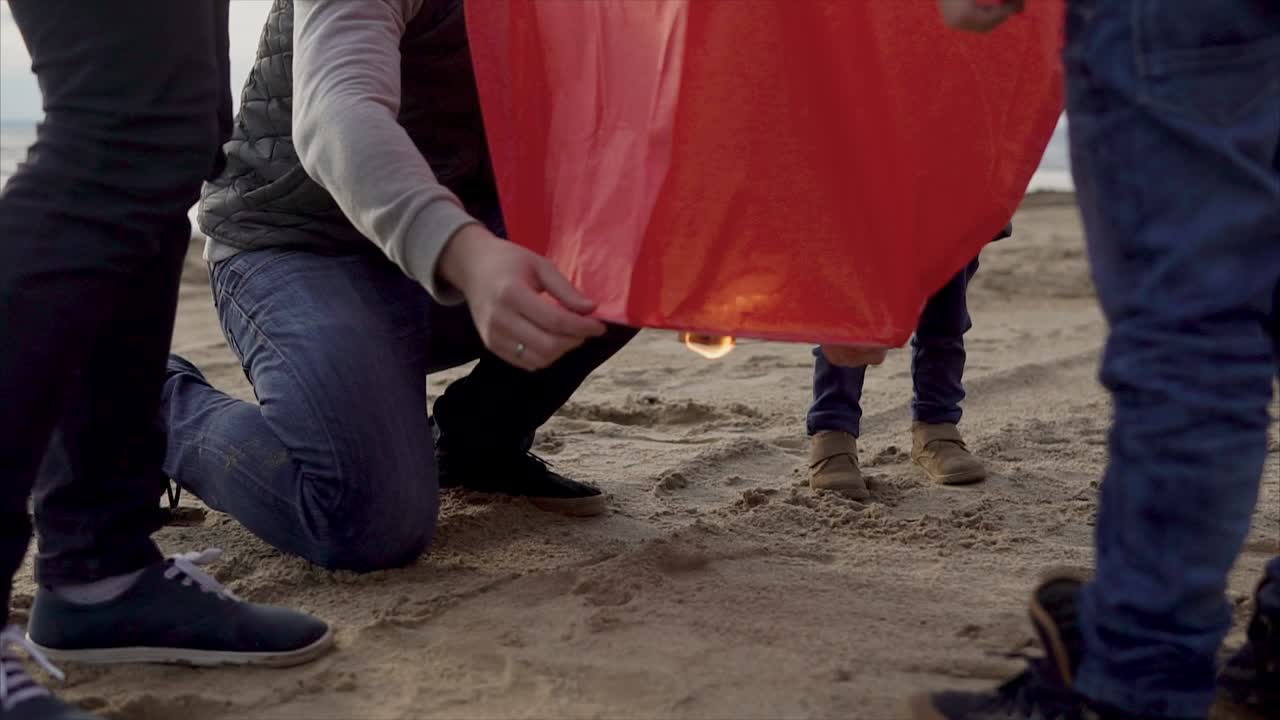Family Releasing Sky Lanterns on the Beach