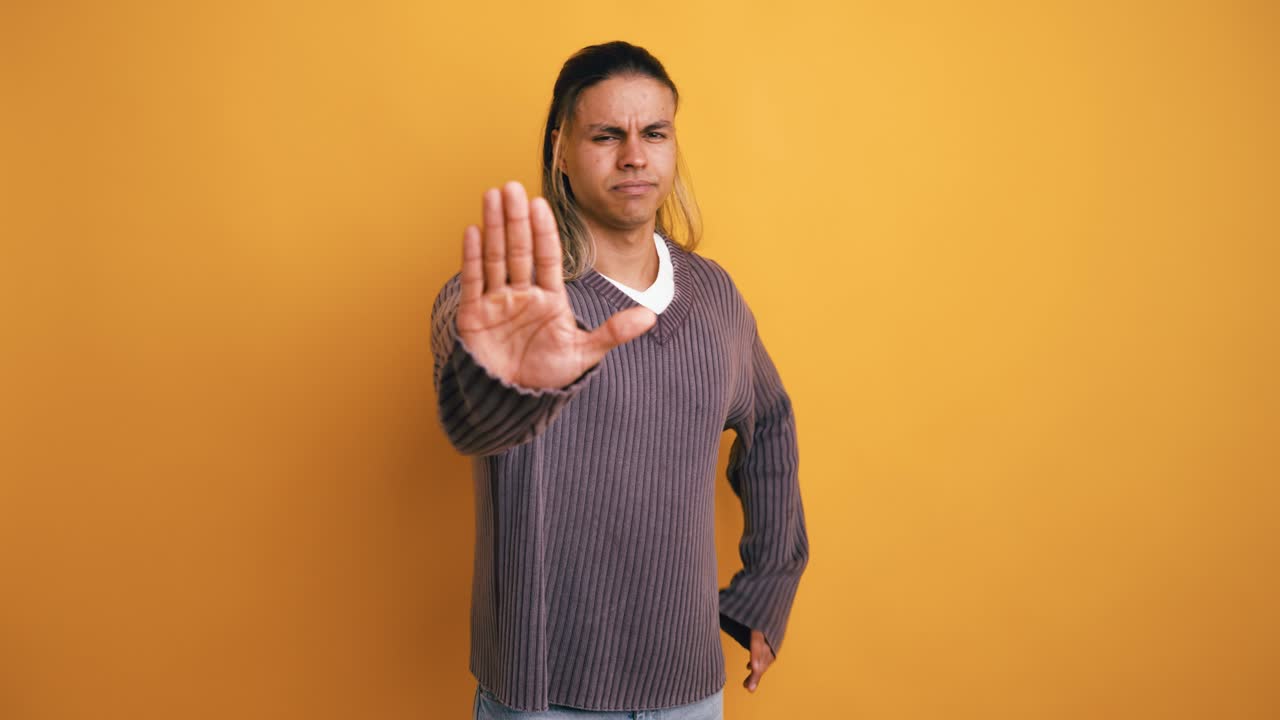 Young Man Making Stop Gesture with Serious Expression