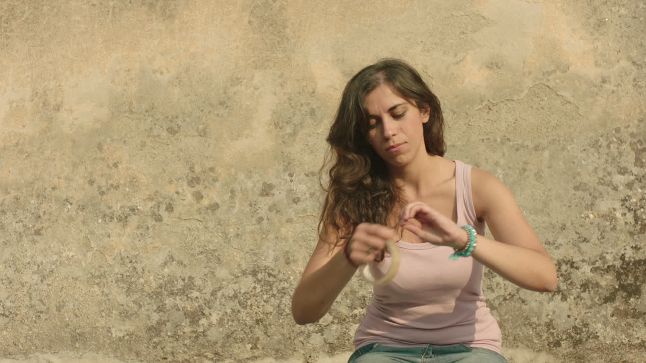 bonita mujer italiana contra una pared astracta haciendo artes - manualidades con cinta transparente