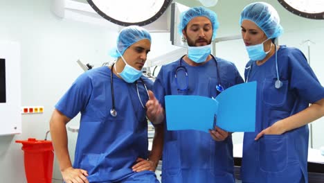 male and female surgeons discussing over report in operation room