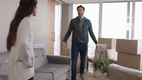 young-couple-moving-house-new-home-owners-smiling-enjoying-successful-move-hugging-in-apartment