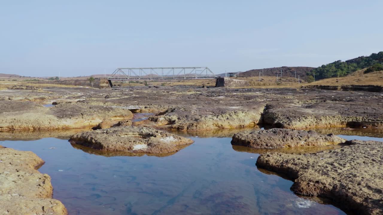 dry river rocky landscape with iron bridge in background at morning