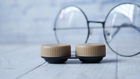 close up of contact lens and eyeglass on table ,