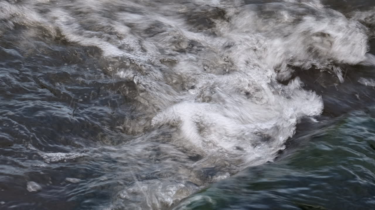 A closeup of fast flowing water in the River Arrow, Warwickshire, UK on a cold autumn day