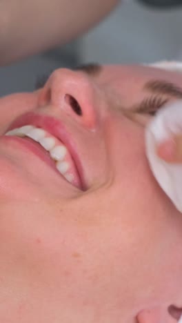beauty master, cosmetologist wipes a woman’s face with napkins after a mask. rejuvenating procedures for the face. care for the beauty of the face