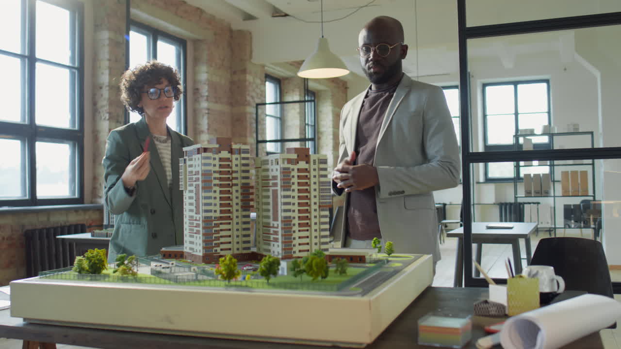 Architects or Developers Discussing a Building Model in an Office
